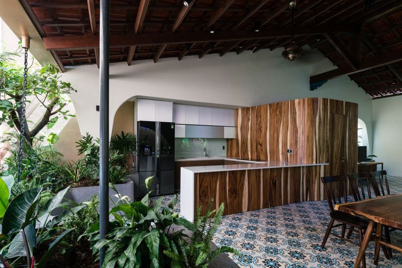 Nét đặc biệt trong không gian căn nhà này là một bức tường gỗ lớn ngăn giữa không gian phòng khách và nhà bếp. Mỗi góc được đặt cây xanh nhỏ giúp điều hòa không khí.